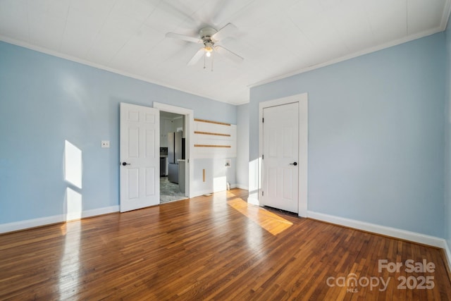 unfurnished bedroom featuring baseboards, hardwood / wood-style flooring, crown molding, and freestanding refrigerator