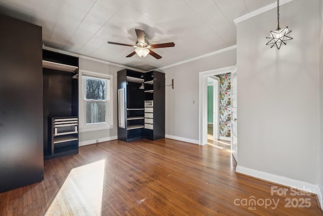 unfurnished living room featuring baseboards, a ceiling fan, wood finished floors, and crown molding