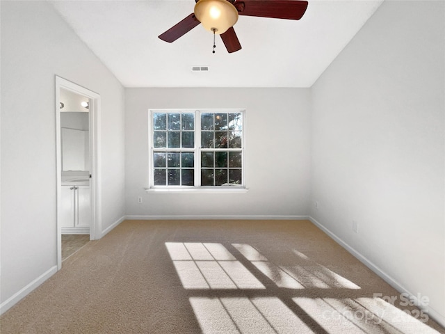 empty room with carpet flooring, visible vents, and baseboards