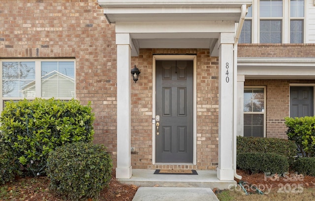 doorway to property with brick siding