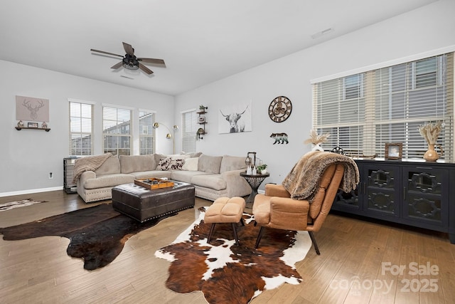 living room featuring a ceiling fan, wood-type flooring, and baseboards