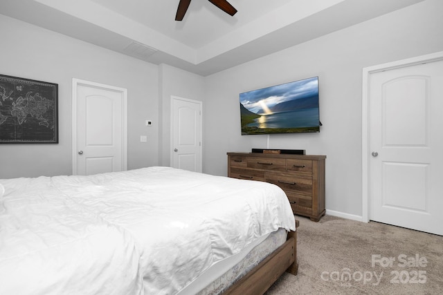 bedroom with visible vents, baseboards, a raised ceiling, a ceiling fan, and carpet floors