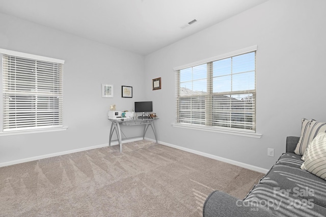 carpeted office space featuring visible vents and baseboards