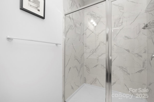 bathroom featuring a marble finish shower