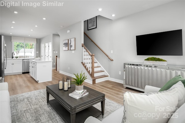 living area with light wood-style flooring, stairs, baseboards, and recessed lighting