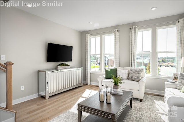 living room featuring a healthy amount of sunlight, light wood finished floors, and baseboards