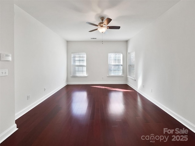 unfurnished room featuring a ceiling fan, baseboards, and wood finished floors