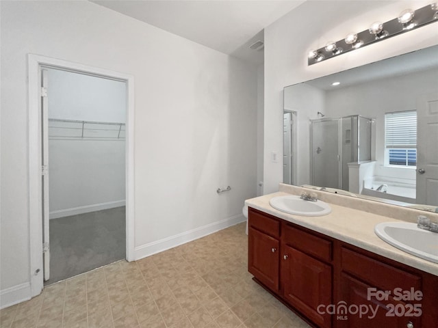 bathroom with a bath, a stall shower, a spacious closet, and a sink