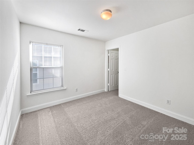 carpeted empty room featuring visible vents and baseboards