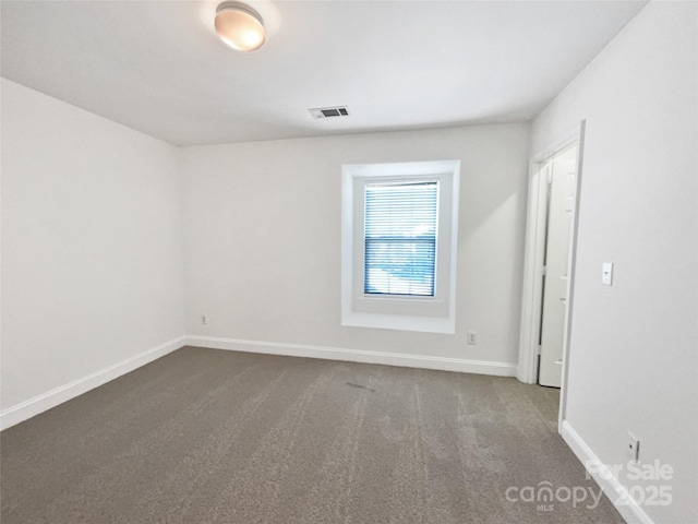 carpeted empty room featuring visible vents and baseboards