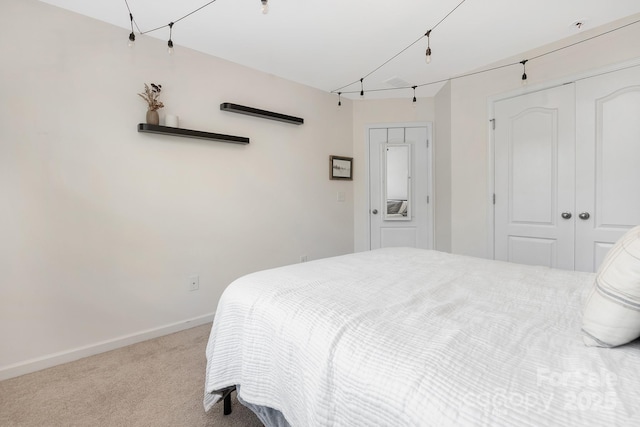 carpeted bedroom with a closet and baseboards