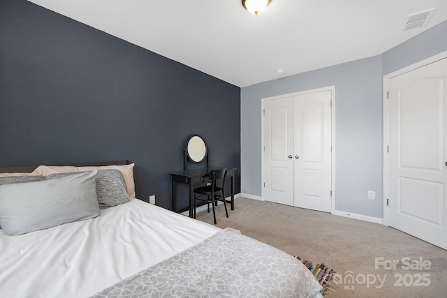 bedroom with a closet, carpet flooring, visible vents, and baseboards