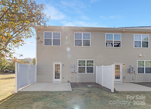 rear view of house featuring a yard, a patio area, and fence