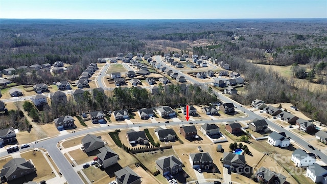 drone / aerial view featuring a residential view and a view of trees