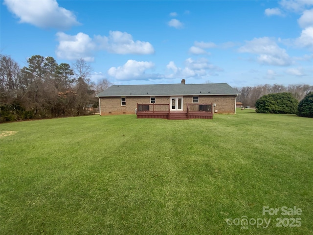 back of house featuring crawl space, brick siding, a lawn, and a deck