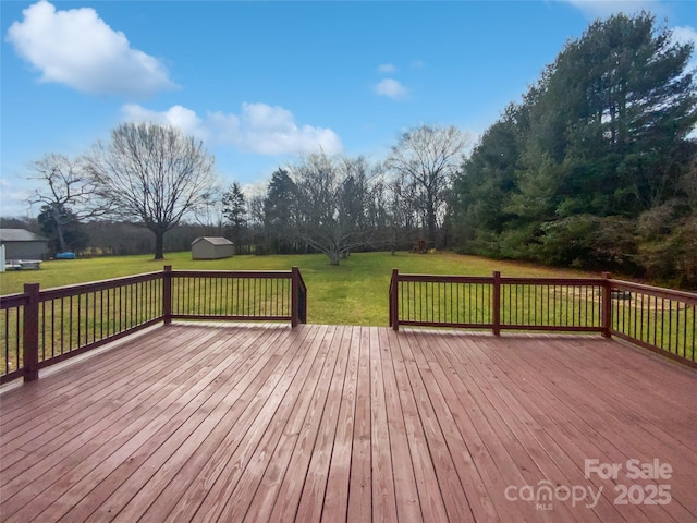 wooden deck with an outbuilding, a yard, and a storage unit