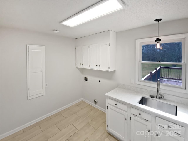 clothes washing area featuring cabinet space, baseboards, a sink, hookup for a washing machine, and electric dryer hookup