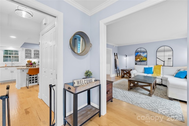 interior space featuring light wood finished floors and ornamental molding