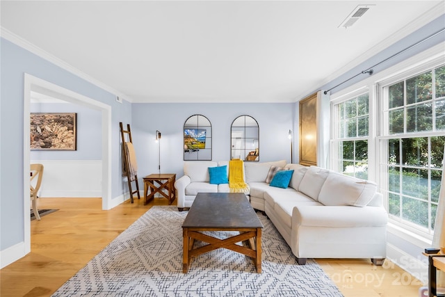 living area featuring ornamental molding, visible vents, light wood-style flooring, and baseboards