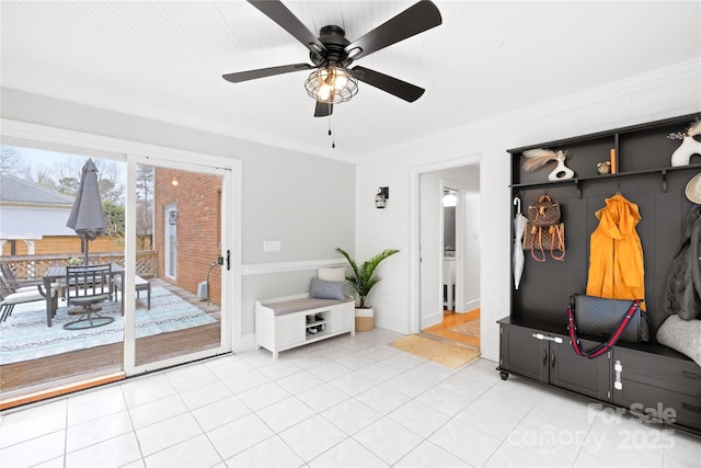 mudroom with light tile patterned floors and crown molding