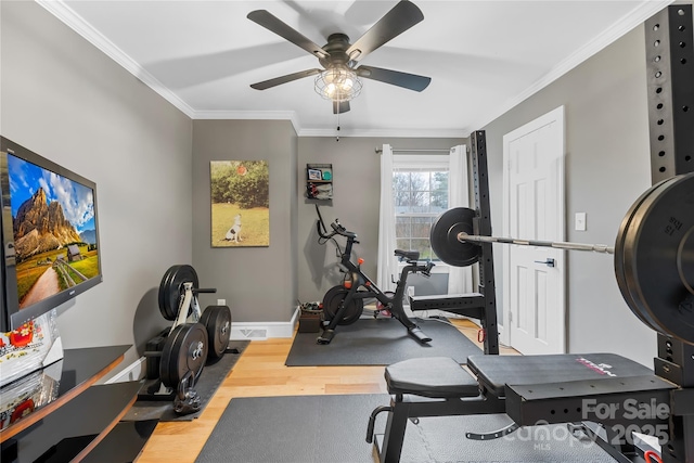 workout room with ceiling fan, ornamental molding, wood finished floors, and baseboards