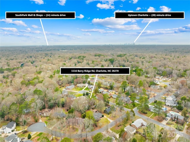 drone / aerial view featuring a residential view and a view of trees