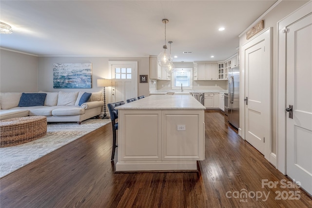 kitchen featuring appliances with stainless steel finishes, dark wood-style flooring, a center island, and white cabinetry