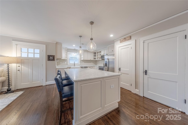 kitchen with dark wood finished floors, white cabinets, appliances with stainless steel finishes, and a kitchen island