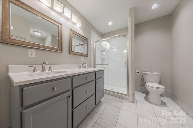 full bathroom featuring a sink, toilet, double vanity, and a shower stall