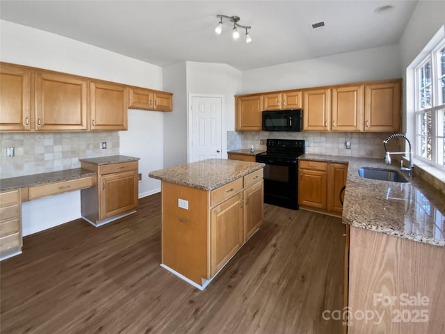 kitchen featuring decorative backsplash, light stone counters, dark wood-style flooring, black appliances, and a sink