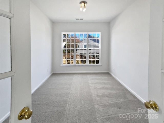 carpeted empty room with baseboards and visible vents