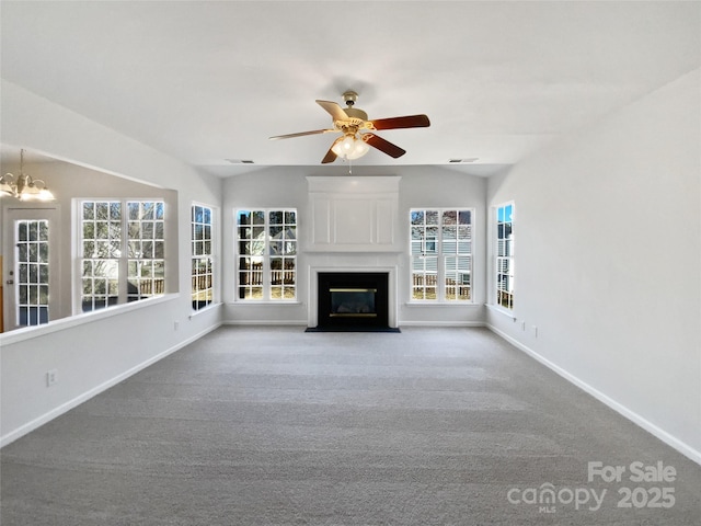 unfurnished living room featuring carpet floors, a fireplace with flush hearth, baseboards, and vaulted ceiling