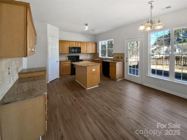 kitchen with visible vents, decorative backsplash, dark wood-style floors, a center island, and black appliances