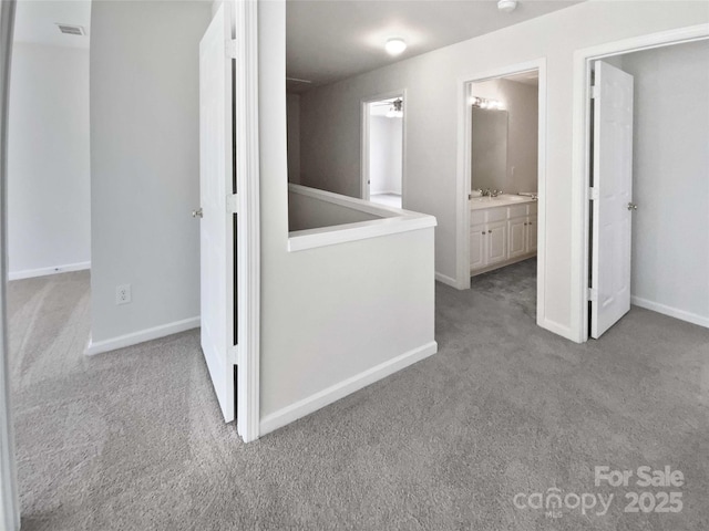 corridor featuring carpet floors, visible vents, and baseboards