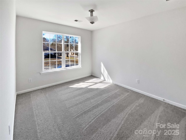 carpeted spare room featuring visible vents and baseboards