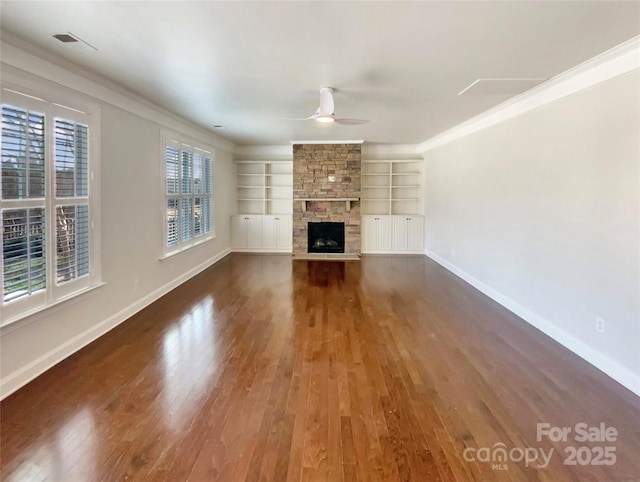 unfurnished living room with baseboards, a ceiling fan, wood finished floors, built in shelves, and a fireplace