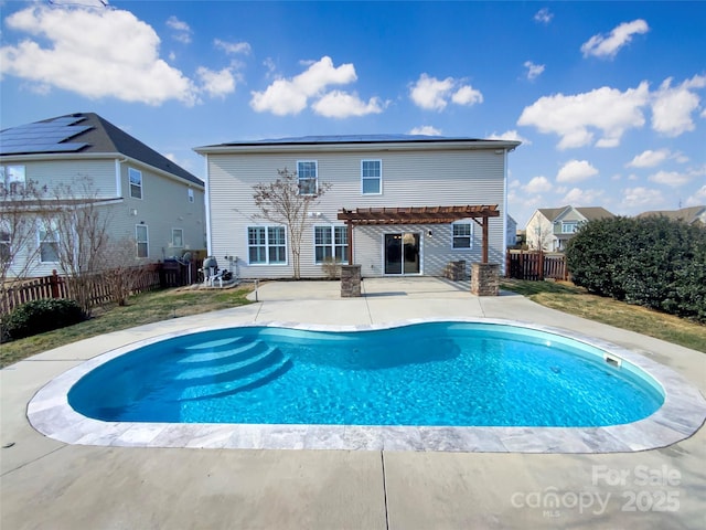 back of house featuring a fenced in pool, solar panels, a fenced backyard, a patio area, and a pergola