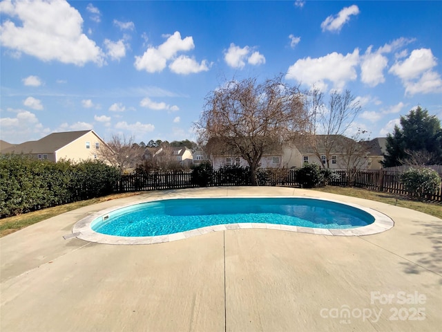 view of swimming pool featuring a fenced in pool, fence private yard, a patio area, and a residential view