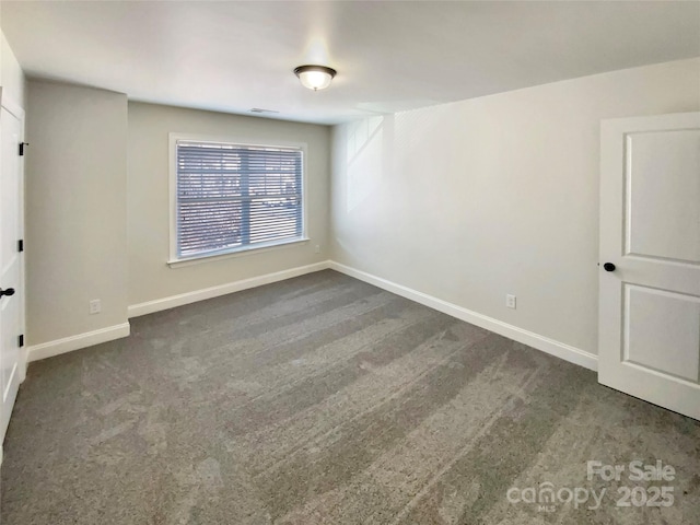 spare room featuring baseboards and carpet flooring