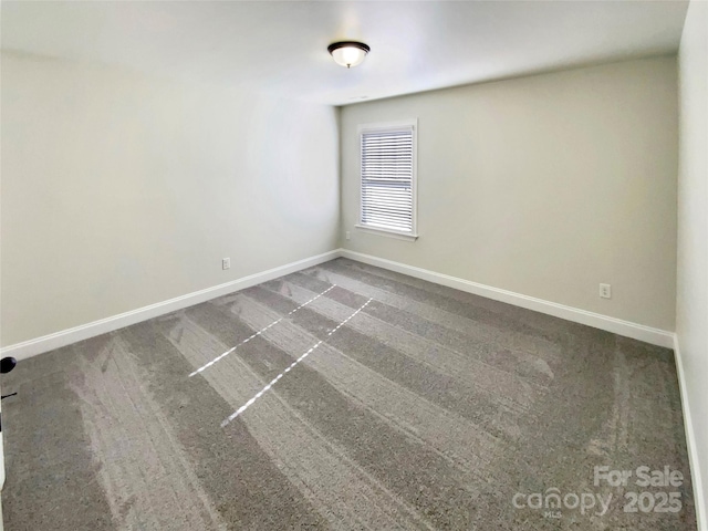 unfurnished room featuring carpet flooring and baseboards