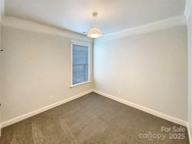 unfurnished room with dark colored carpet and baseboards