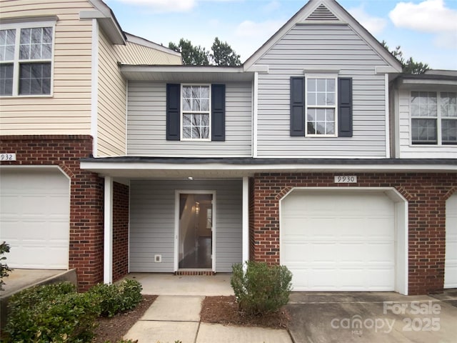 view of property with a garage and brick siding