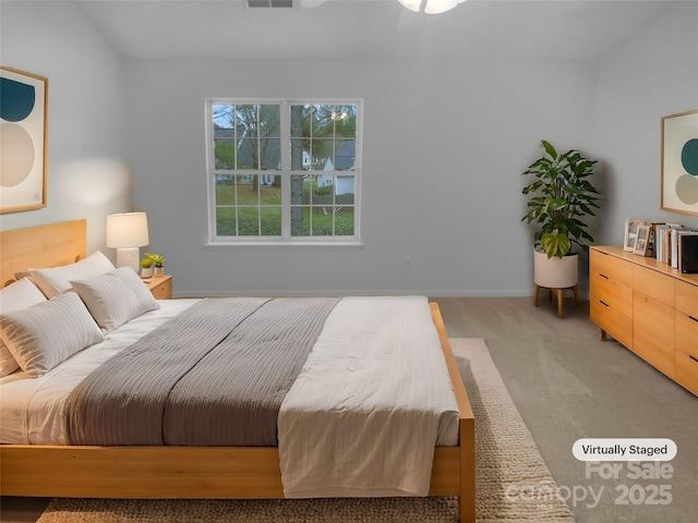 bedroom featuring baseboards, visible vents, and light colored carpet