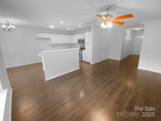 unfurnished living room featuring recessed lighting, dark wood-style flooring, baseboards, and ceiling fan with notable chandelier