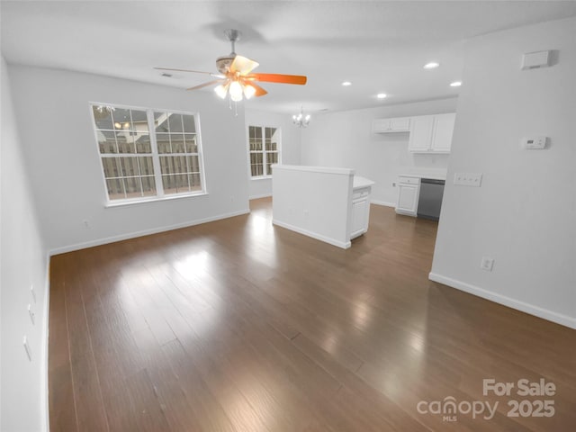 unfurnished living room with recessed lighting, baseboards, dark wood-style flooring, and ceiling fan with notable chandelier