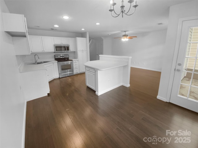 kitchen with dark wood-style floors, stainless steel appliances, a sink, and recessed lighting