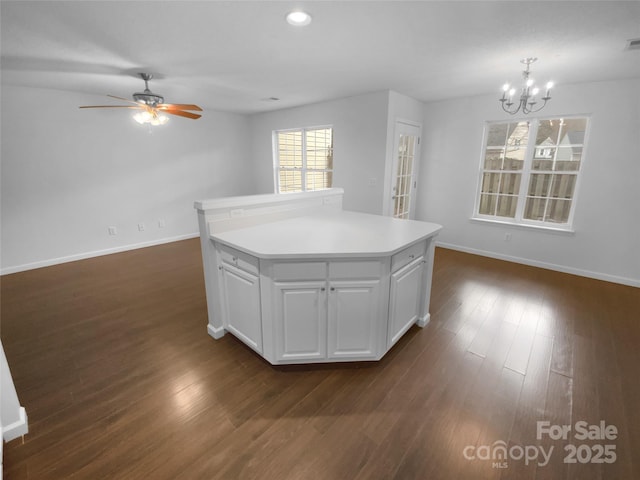 kitchen with light countertops, dark wood finished floors, white cabinetry, and baseboards