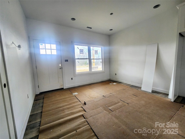 entrance foyer with wood finished floors, visible vents, and baseboards