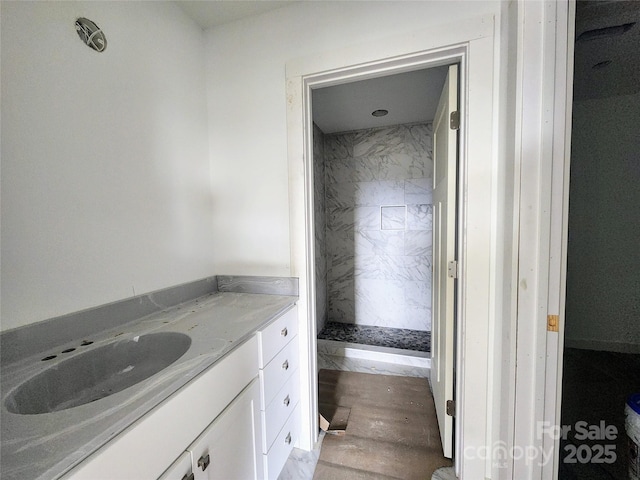 bathroom featuring a stall shower, wood finished floors, and vanity