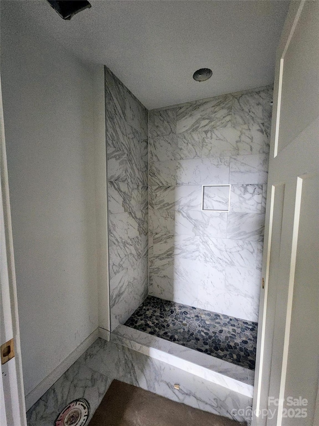 full bathroom with marble finish floor and a shower stall